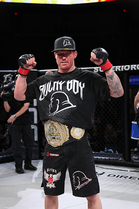 Bristol Marunde inside a cage with his title belt.